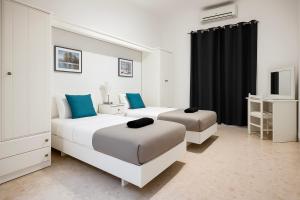 Dos camas en un dormitorio con azul y blanco. en Waterfront Panorama Massive Three Bedrooms Flat 8S, en Sliema