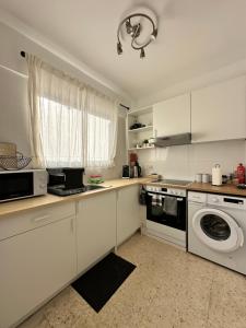 a kitchen with white cabinets and a washer and dryer at Two Bedroom Sea View Townhouse-Villa Libellula in Chlorakas +19 photos