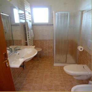 La salle de bains est pourvue d'un lavabo, d'une douche et de toilettes. dans l'établissement Residence Miralago Rooms & Apartments, à Manerba del Garda