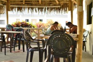 two women sitting at tables and chairs at a restaurant at Montañita Garden Hostal in Montañita