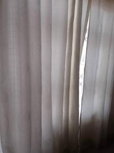 a window with white curtains in a room at B vhonani in Polokwane
