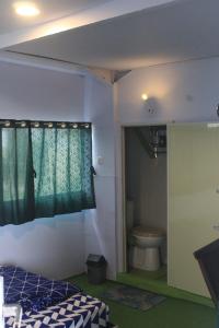 a bedroom with a bed and a toilet in a room at Wong Pai Ton Villa in Ngadisari