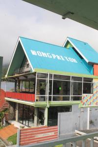 a building with a blue roof and a restaurant at Wong Pai Ton Villa in Ngadisari