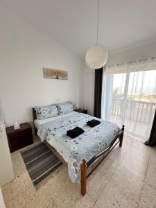 a bedroom with a bed and a large window at Two Bedroom Sea View Townhouse-Villa Libellula in Khlorakas