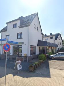 a street sign in front of a white building at Cosmic Living by Tayo Ajayi in Zwickau