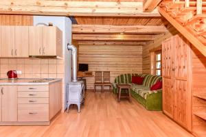 eine Küche und ein Wohnzimmer in einer Blockhütte in der Unterkunft Stirnelės viensėdis in Stirniai + 49 Fotos