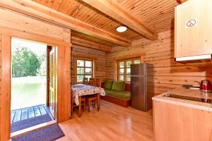 eine Küche und ein Esszimmer in einem Blockhaus in der Unterkunft Stirnelės viensėdis in Stirniai