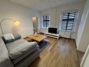 ein Wohnzimmer mit Sofa und Tisch in der Unterkunft Kato Suite in Oldenburg