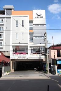 a building with a parking lot in front of it at Neotel Hotel City Centre in Tanjungredep