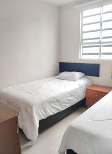 een kleine slaapkamer met een bed en een raam bij Cozy House with Private Garden in Pachuca in Pachuca de Soto