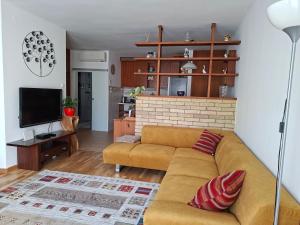 a living room with a couch and a tv at Centrum apartman in Szekszárd