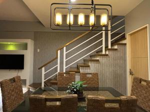 a dining room with a table and a staircase at CAROLA in Pico de Loro in Nasugbu