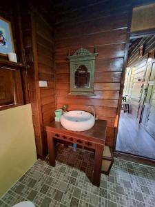 baño con lavabo en una pared de madera en Huen Tip Viman, en Ban Nong Ho