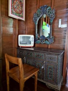 Un televisor encima de una cómoda con un espejo. en Huen Tip Viman, en Ban Nong Ho