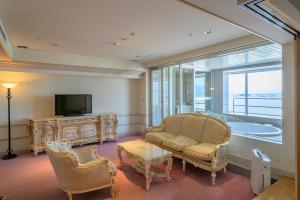 een woonkamer met een bank en een televisie bij Tendo Hotel in Tendo