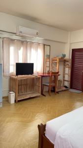 a bedroom with a bed and a desk with a television at A Day Rayong in Ban Pa Khan +88 photos