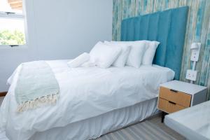 a bedroom with a white bed with a blue headboard at Towny Lodge in Kokstad