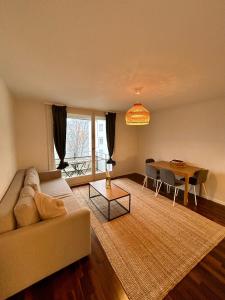 un soggiorno con un divano e un tavolo di Simple Apartment with Essentials a Zurigo