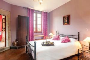 ein Schlafzimmer mit einem großen weißen Bett mit rosa Kissen in der Unterkunft Domaine Le Prieuré in Chaumont-le-Bourg