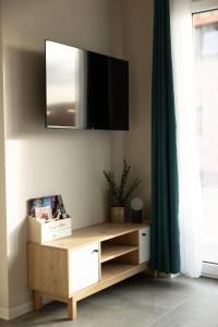 a living room with a tv on the wall at Maison MUGUET 2 SPA-PARKING-COLMAR in Wickerschwihr