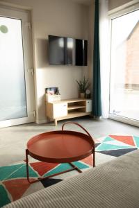 a living room with a coffee table in front of a window at Maison MUGUET 2 SPA-PARKING-COLMAR in Wickerschwihr