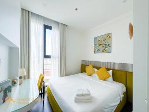 een slaapkamer met een bed met gele kussens en een raam bij The Hillside Seaview Apartment Phu Quoc in Phu Quoc +33 foto's