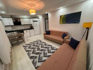 un salon avec un canapé et une cuisine dans l'établissement Very hygienic apartment close to the center and the airport, à Dalaman
