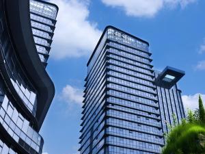 two tall buildings against a blue sky at Hotel Indigo Zhuhai Xiangzhou by IHG in Zhuhai