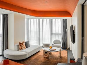 a living room with a couch and a table at Hotel Indigo Zhuhai Xiangzhou by IHG in Zhuhai