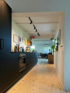 a kitchen with black cabinets and a hard wood floor at Sommerhus Med Udsigt Over Dalbybugten in Mesinge
