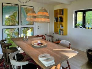 a dining room with a wooden table and chairs at Sommerhus Med Udsigt Over Dalbybugten in Mesinge
