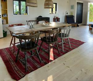 a wooden table and chairs on a rug in a living room at Sommerhus Med Udsigt Over Dalbybugten in Mesinge +31 photos