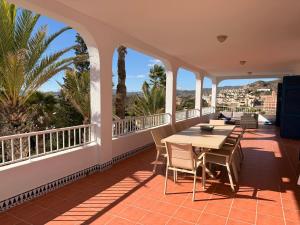 a balcony with a table and chairs and palm trees at Villa Nico - By Aloha Palma in Águilas