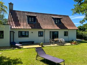 Casa blanca con patio, mesa y sillas en Holiday Home With View Of Dalby Bay, en Mesinge