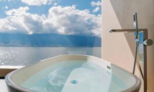 a bath tub in a bathroom with a view of the ocean at Dali Rushi Jiuxi Sea View Holiday Inn in Dali Airport +52 photos