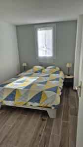 1 dormitorio con 1 cama con edredón amarillo y azul en Maison 100m de la plage avec parking securise plus fibre optique internet, en Valras-Plage 16 fotos más