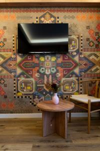 a tv on a wall in a room with a table at MonteRai in Văliug