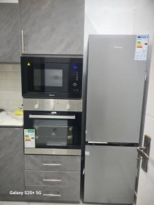 a microwave and a refrigerator in a kitchen at WHITE FLAT ALMADIES in Dakar