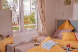 a bedroom with two beds and a window at BB House Villa in Da Thanh