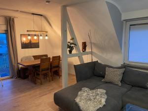 a living room with a couch and a table at Konfortable Wohnung mit Balkon und Gartenblick in Hungen