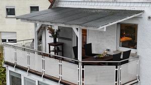 a balcony with a table and chairs on a building at Konfortable Wohnung mit Balkon und Gartenblick in Hungen
