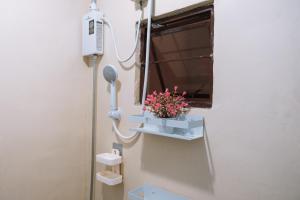 a bathroom with a flower pot on a wall at JZ Homestay - Cozy Home near SM Savemore, Caraga State University & BMC Hospital in Butuan