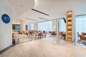 een restaurant met tafels en stoelen in een gebouw bij Holiday Inn Express Langfang Sanhe by IHG in Sanhe