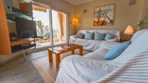 a living room with a couch and a tv at SeaHomes Vacations - NAUTIC MARITIME Apt in Blanes