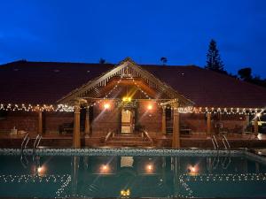 a house with a swimming pool at night at Sabera Heritage Homestay in Sakleshpur