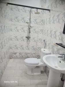 a white bathroom with a toilet and a sink at WHITE FLAT ALMADIES in Dakar
