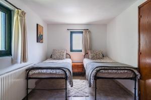 ein Zimmer mit zwei Einzelbetten und einem Fenster in der Unterkunft Mountain Retreat in Kyperounta