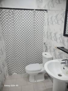 a white bathroom with a toilet and a sink at WHITE FLAT ALMADIES in Dakar +4 photos
