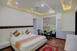 a bedroom with a bed and a table and chairs at Hotel Sehej Continental At Karol Bagh in New Delhi
