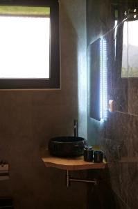 a bathroom with a bowl sink and a window at Dreamy Garden Cabin in Gundauri